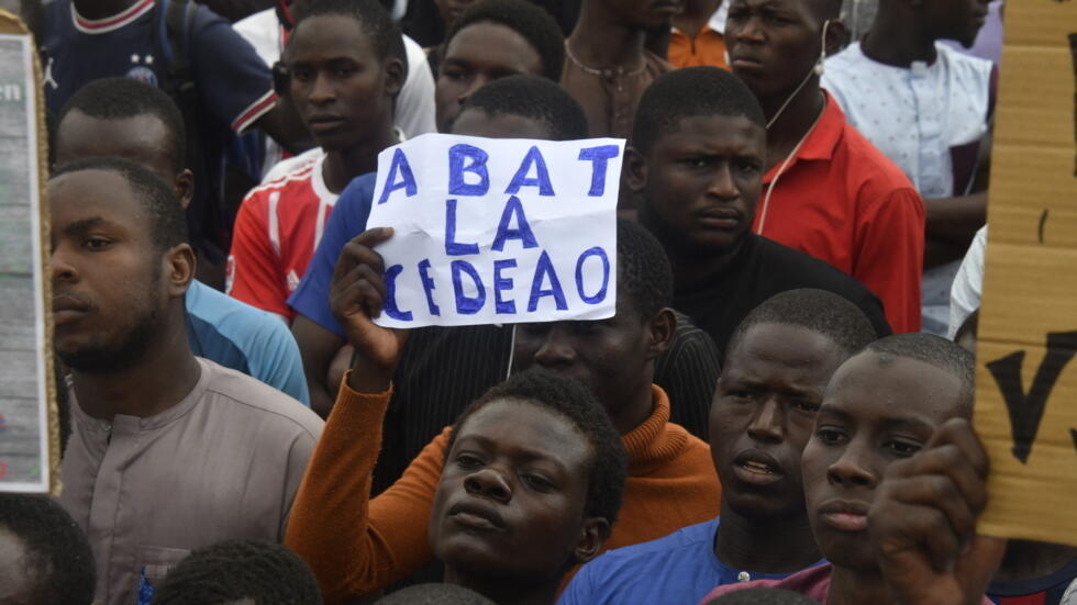 Protesters hold placards denouncing the Economic Community of West African States (ECOWAS) during a demonstration on independence day in Niamey on August 3, 2023.