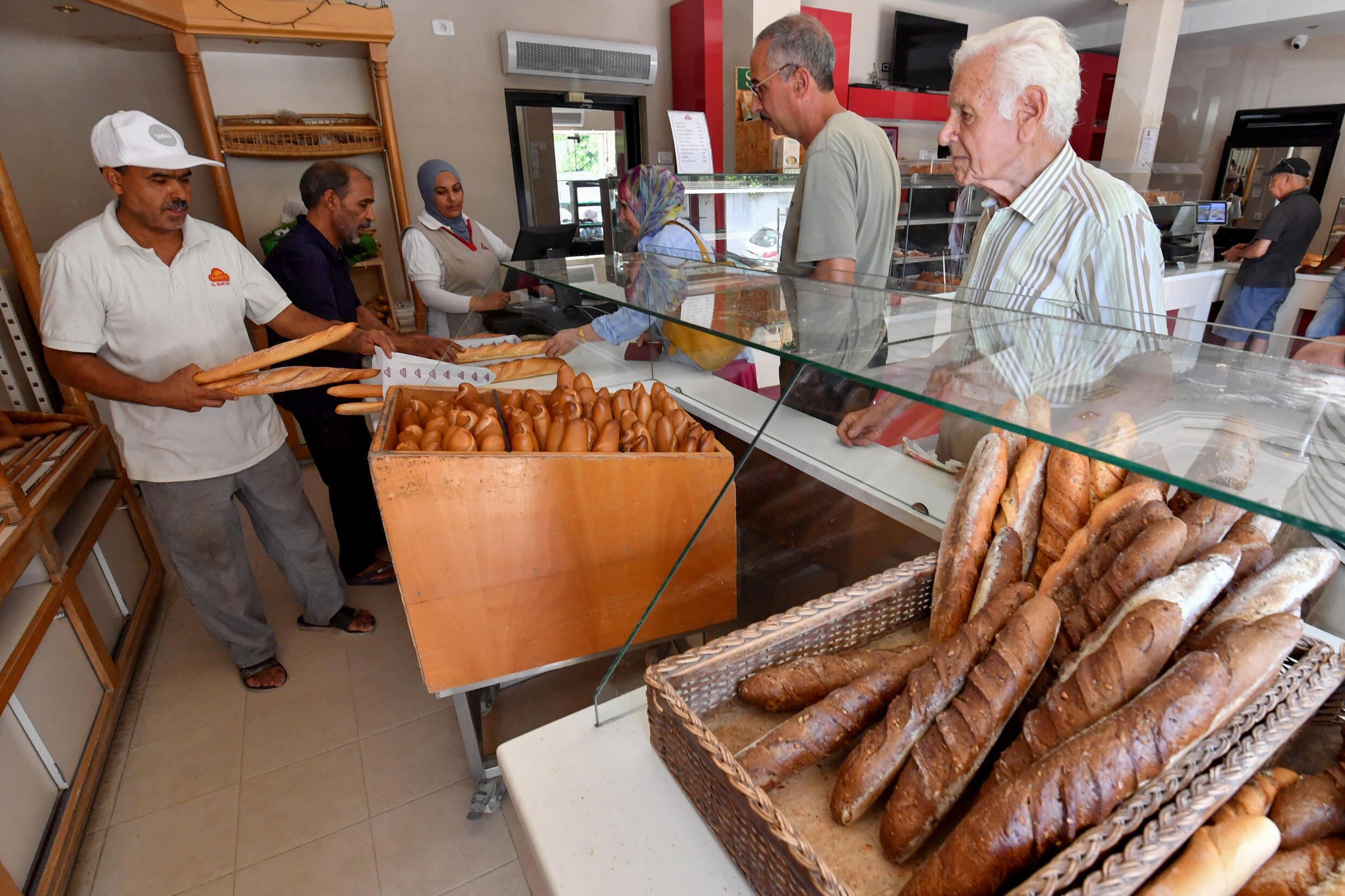 Employees work at a bakery selling baguettes in Tunis on August 7, 2023.