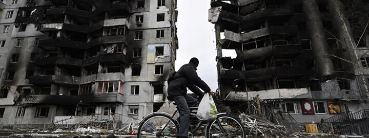 A cyclist passes by a destroyed building in the town of Borodianka, northwest of Kyiv, on April 6, 2022.
